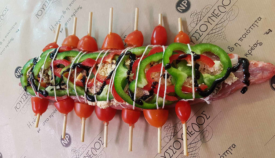 pork fillet stuffed with feta cheese, olives, sun-dried tomatoes and spices with balsamic cream and cherry tomatoes at 'Roussounelos Meat Market'